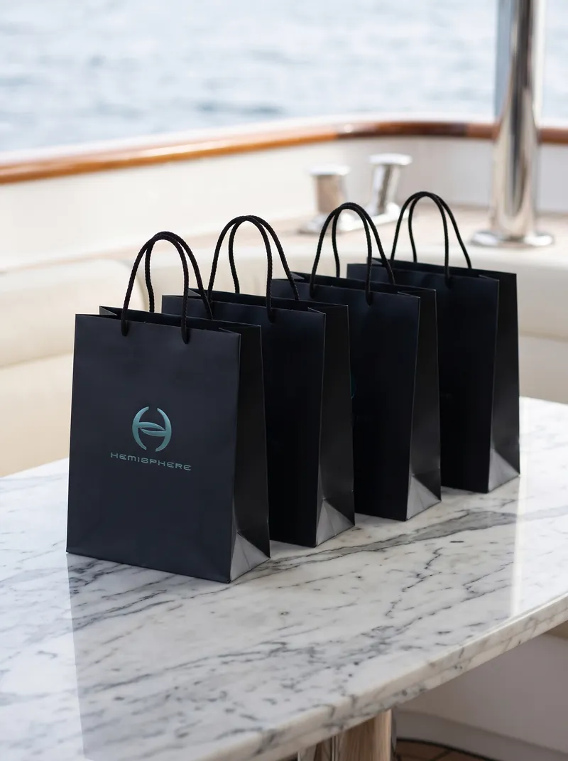 Branded gift bags on a marble table aboard